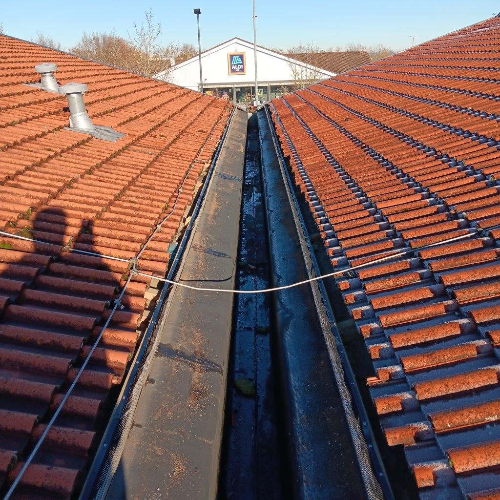 Reinigung der Dachrinne einer Gewerbeimmobilie